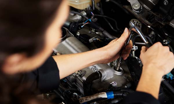 Automotive student working on a car engine