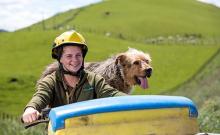Agriculture student on quad bike with dog